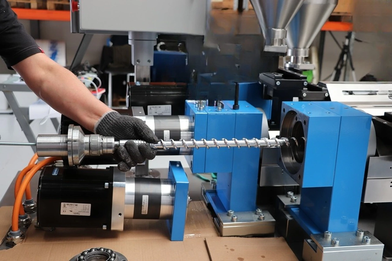 Technician assembling a laboratory extruder screw and drive system in Denmark